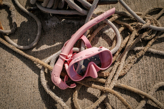 Pink snorkel mask on ropes on a dock