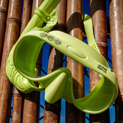 Green dive mask against a bamboo background